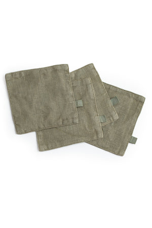 A set of four Jenny Graham Home linen coasters on a white surface.