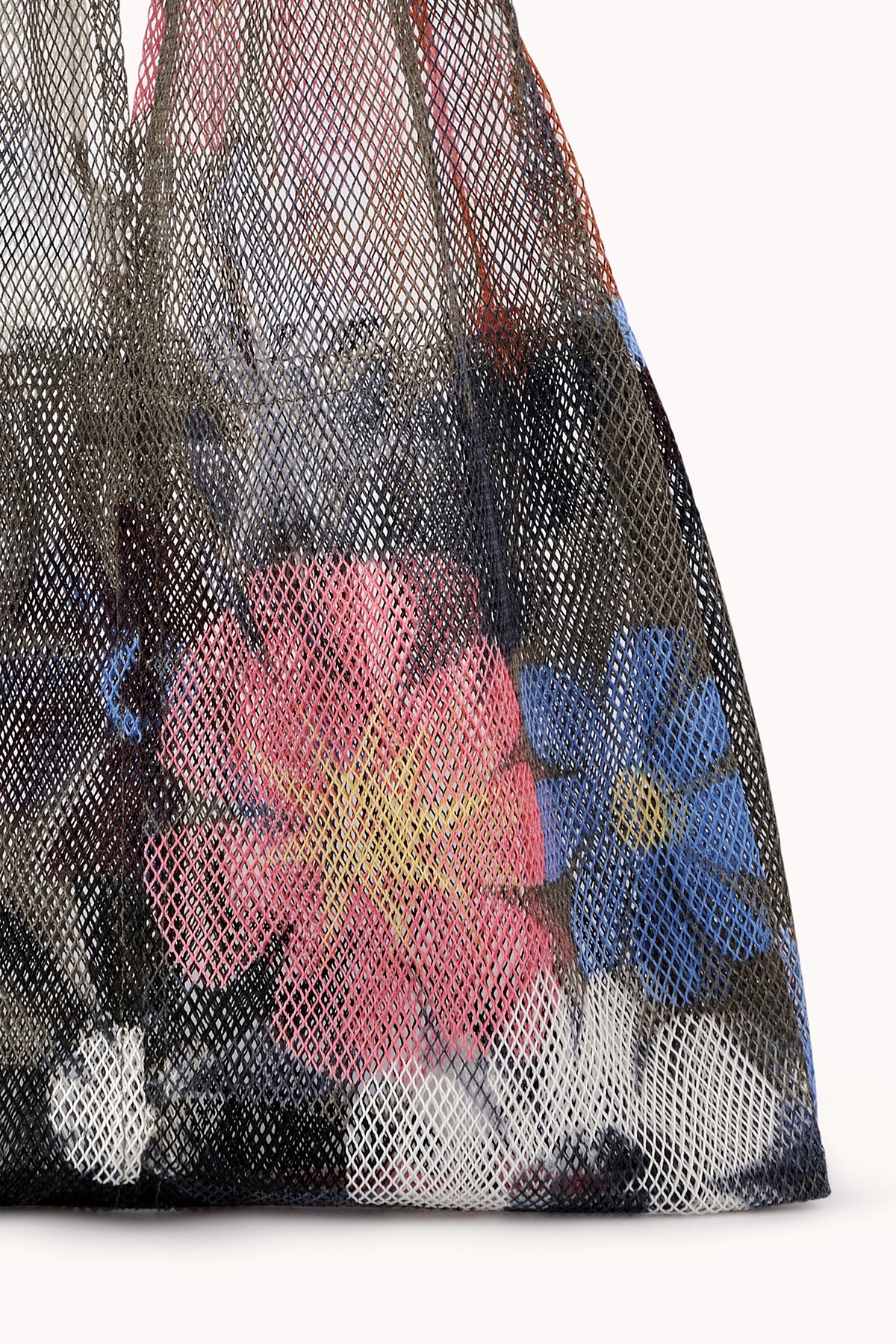 A LARGE FLORAL PRINT MESH TOTE BY EPICE from Epice, featuring bold colors and vibrant floral prints, holds assorted luxe accessories.-24508344139969