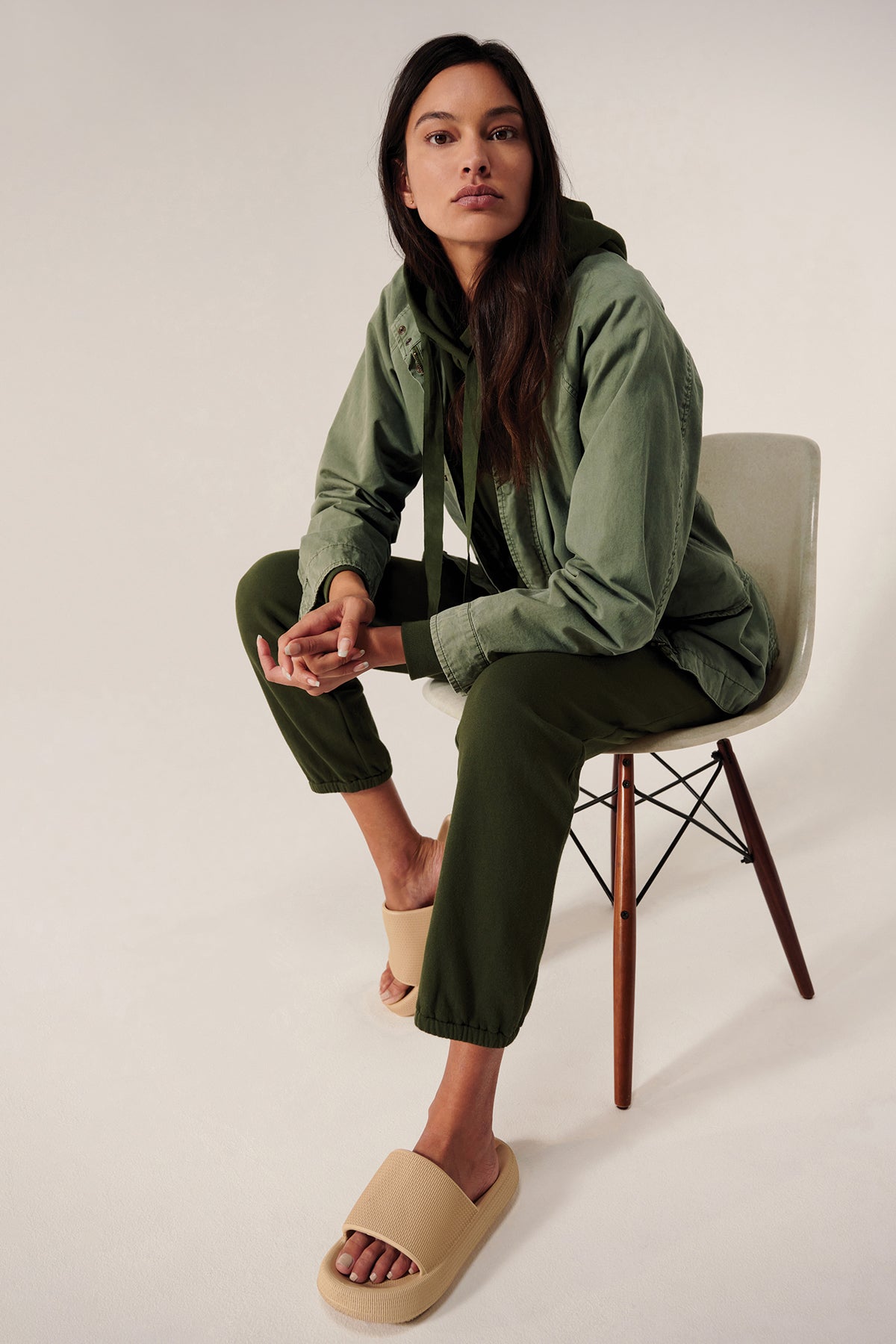 A model is sitting on a chair in a Velvet by Jenny Graham Melrose Jacket and sandals.