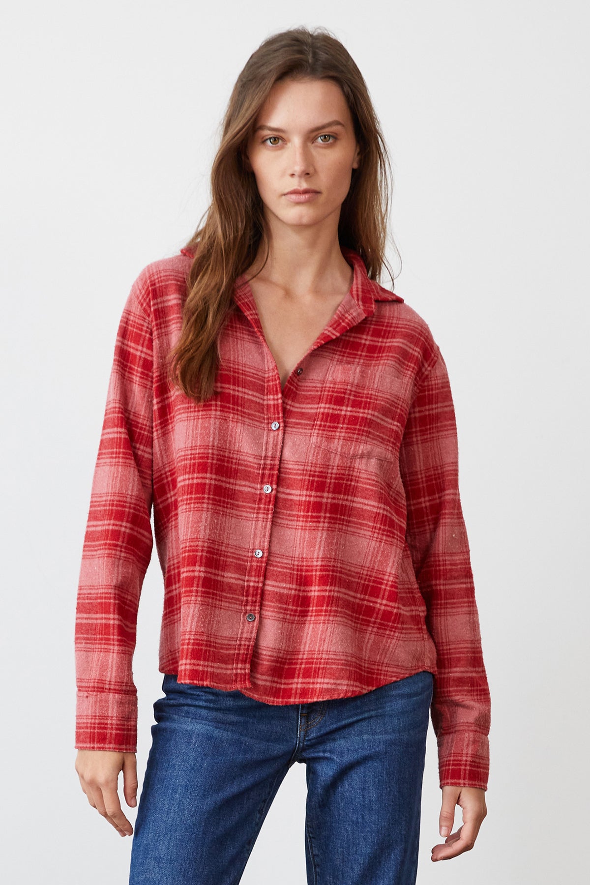 A person with long hair is wearing the RUZ PLAID BUTTON-UP SHIRT by Velvet by Graham & Spencer and blue jeans while standing against a plain background.-7869771153489