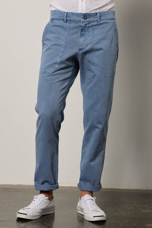 A man wearing the Velvet by Graham & Spencer RALPH SANDED TWILL PANT and white sneakers.