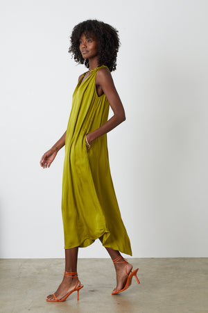 Tala dress in meadow green side with orange sandals