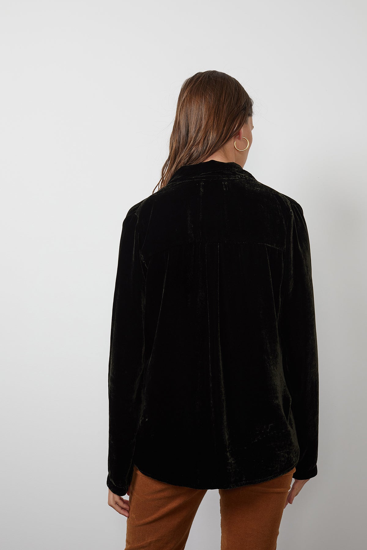 A person with long hair wearing a Velvet by Graham & Spencer JENSINE SILK VELVET BUTTON-UP SHIRT in black and brown pants is seen from the back against a plain white background.-15201374503105
