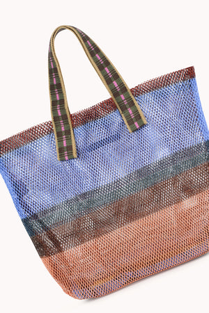 The SMALL STRIPED MESH TOTE BY EPICE features bold horizontal stripes in blue, brown, orange, and red on natural fiber mesh, complemented by two green handles with pink and black stripes. Brand: Epice.