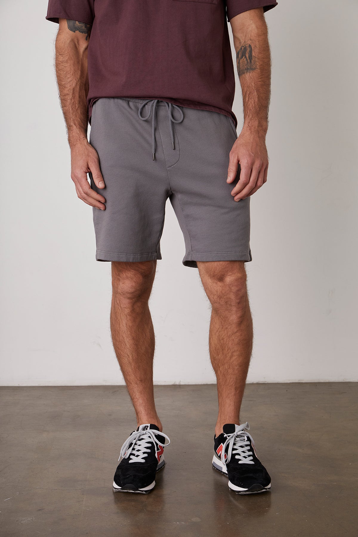The man is wearing a maroon t-shirt and Velvet by Graham & Spencer JAXSON DRAWSTRING SHORT.-22944804536513