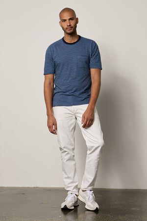 Jeremy Crew Neck Tee with medium and dark blue stripes, front pocket, paired with white denim full length front with New Balance sneakers