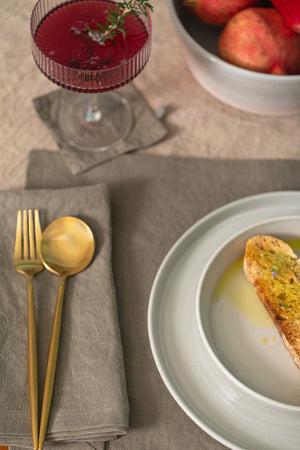 a LINEN COASTERS (SET OF 4) by Jenny Graham Home with bread and a glass of wine.