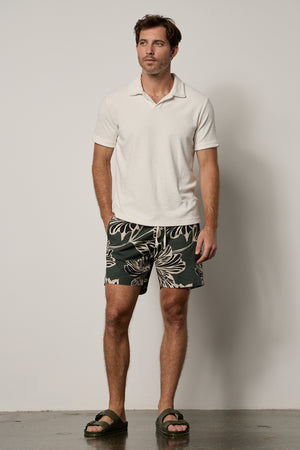 Colt Short front in catalina print with bold, black and cream pattern on dark green background with Boris Polo in ecru, full length front with Birkenstocks