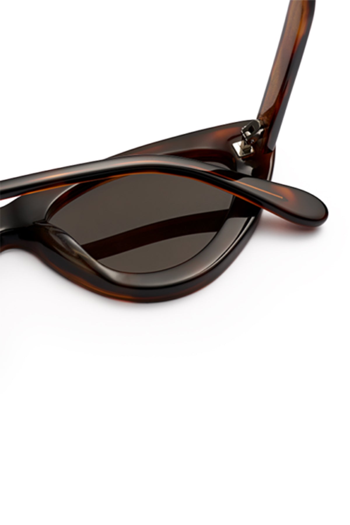 Close-up of Chimi’s 006 BY CHIMI EYEWEAR—tortoiseshell cat-eye sunglasses with dark lenses, one arm partially folded, on a white background. These stylish unisex shades are from the brand Chimi.-6542026047569