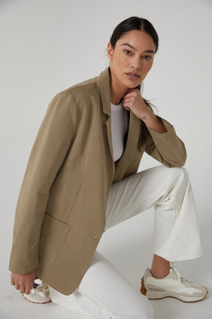 The model is wearing an ECHO BLAZER by Velvet by Jenny Graham and white pants.