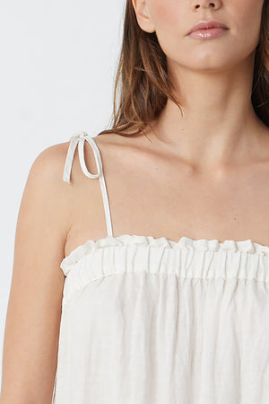 The model is wearing a white CHARLIE LINEN TIERED DRESS by Velvet by Graham & Spencer with ruffles.