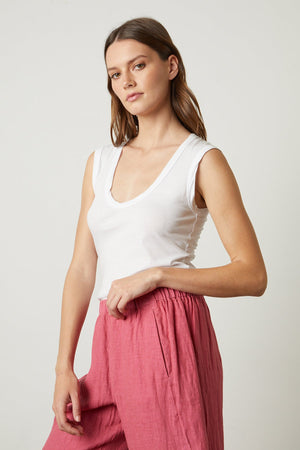 Model standing showing waist and pocket detail of Lola linen pant in calypso and Estina tank in white
