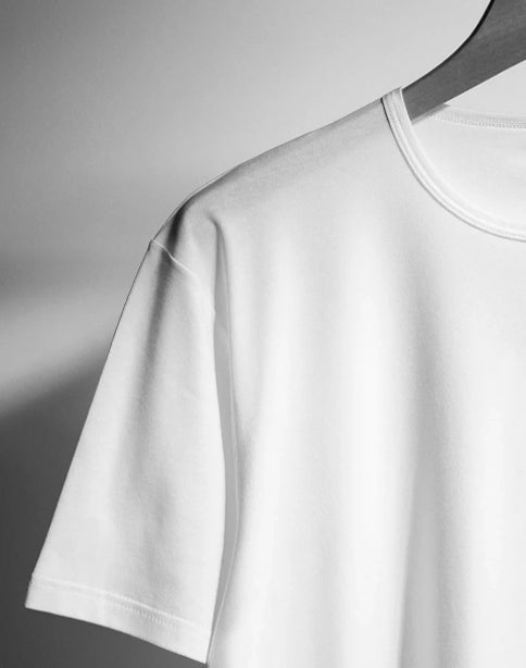 Close-up view of a white short-sleeve T-shirt showcasing its crew neckline and sleeve hem on a hanger