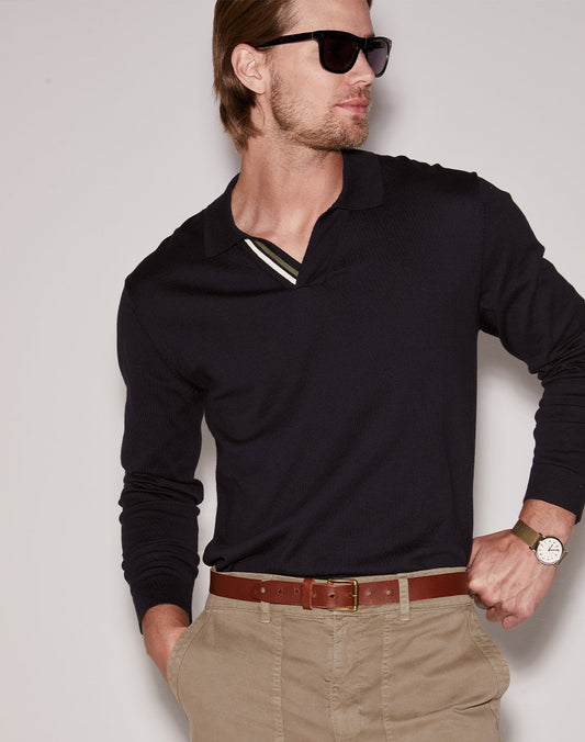 Close-up of a man wearing a black long-sleeve polo shirt with a striped collar against a light background