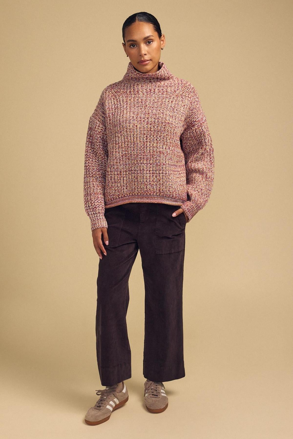 A person stands against a beige background wearing the DENNIE SWEATER from Velvet by Graham & Spencer, paired with brown wide-leg pants and beige sneakers, looking directly at the camera with a neutral expression. The cozy texture of the DENNIE SWEATER adds warmth and style to the ensemble.-42181521539265