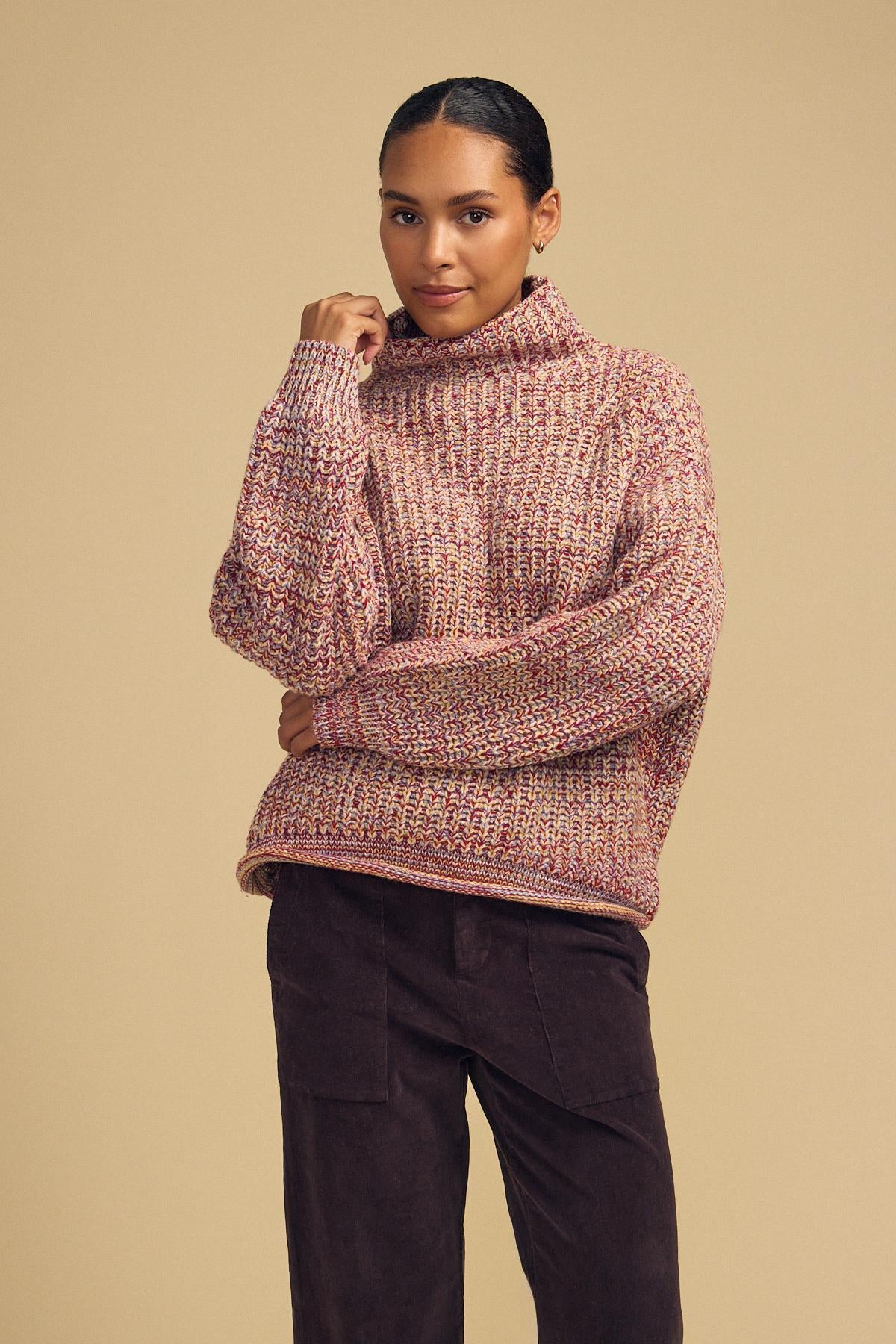 A woman wearing the DENNIE SWEATER by Velvet by Graham & Spencer, paired with dark pants, poses against a plain beige background.-42181521670337