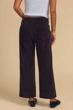 A person seen from behind wears a light blue sweater and dark, high-rise, wide-leg VERA CORDUROY PANT.
