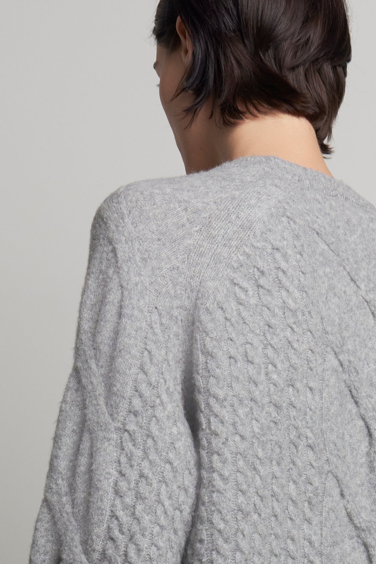   A person with short dark hair is seen from behind wearing the Wilshire Sweater, crafted by Velvet by Jenny Graham from a luxurious wool-yak blend. 