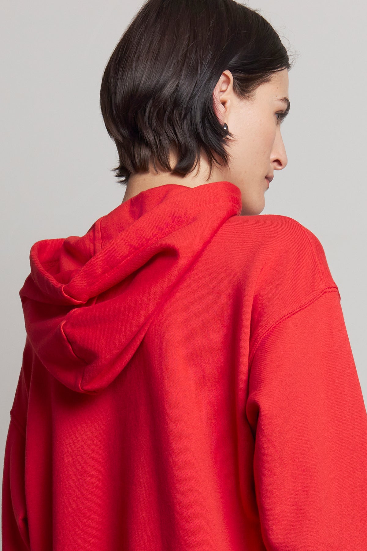 An individual wearing the OJAI HOODIE by Velvet by Jenny Graham, facing away to reveal the back and side profile against a neutral backdrop.-38318612545729