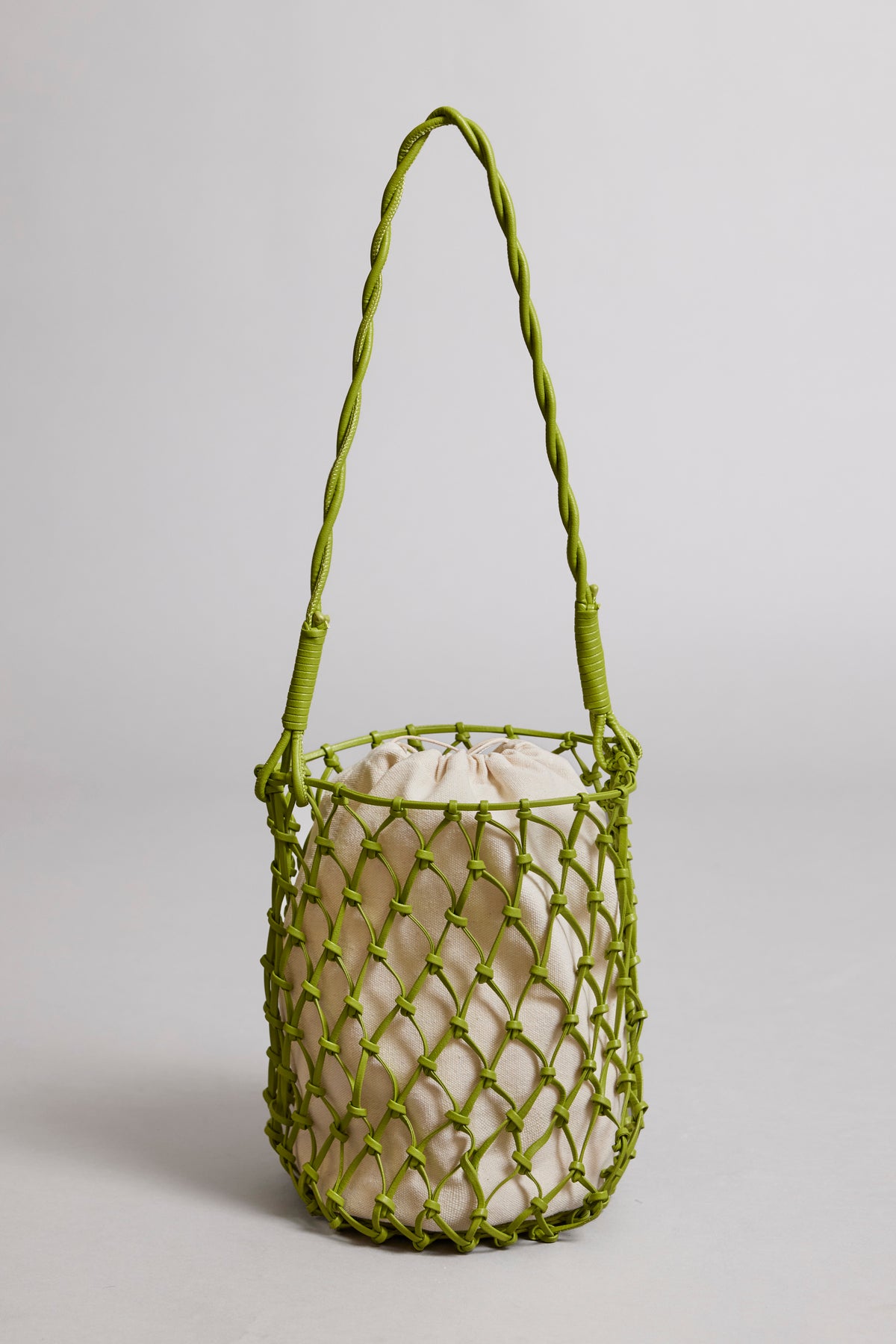 A lime green Velvet by Graham & Spencer mesh-designed tote bag with a braided strap and a light beige drawstring pouch inside, set against a neutral background.-36280402247873
