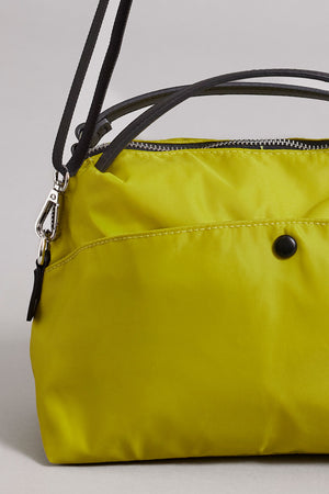 A yellow Velvet by Graham & Spencer NYLON CROSSBODY BAG with black leather handles and shoulder straps, featuring a secure zipper closure and a black button detail on the front.