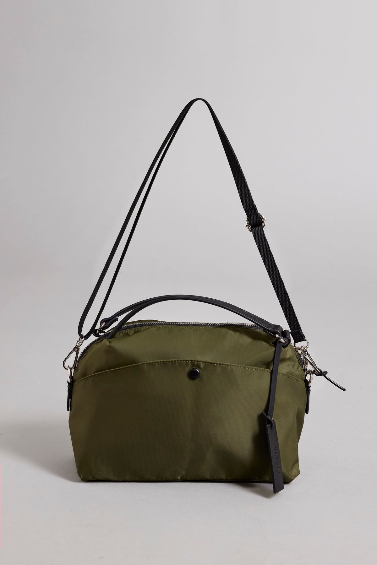   A small olive green Nylon Crossbody Bag by Velvet by Graham & Spencer, crafted from durable nylon, featuring a black adjustable strap, front pocket, and secure zipper closure. 