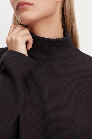 A woman in a Velvet by Graham & Spencer ALEC BRUSHED RIB MOCK NECK TOP.