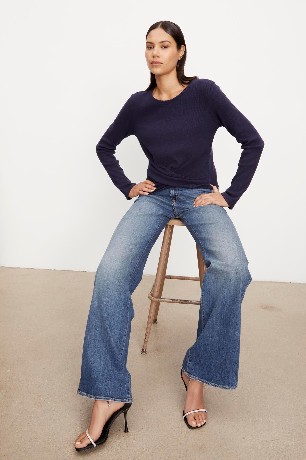   The model is wearing a Velvet by Graham & Spencer GEONNA BRUSHED RIB TOP and high - waisted jeans. 