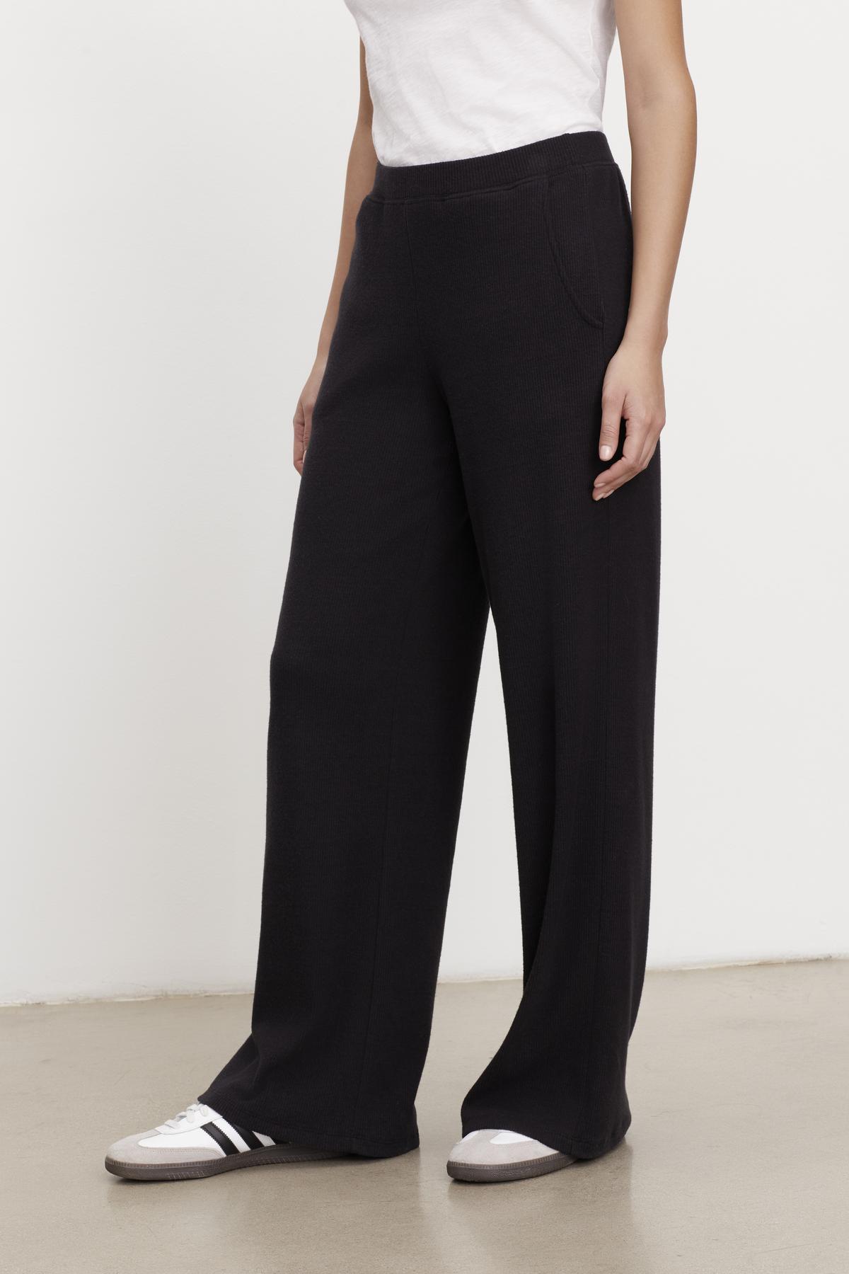   A woman wearing Velvet by Graham & Spencer's KACIE BRUSHED RIB PANT wide leg pants and a white t-shirt. 