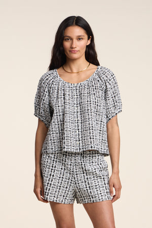 Model wearing the ANGIE TOP by Velvet by Graham & Spencer—a black-and-white gingham set—standing against a plain light background.