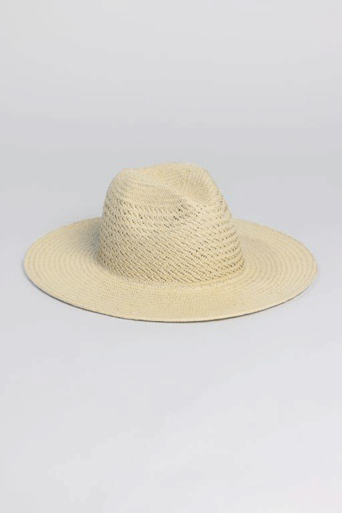 The LUXE VENTED PACKABLE HAT by Velvet by Graham & Spencer is crafted from natural paper straw with a textured weave and features a wide brim, shown on a plain light gray background.