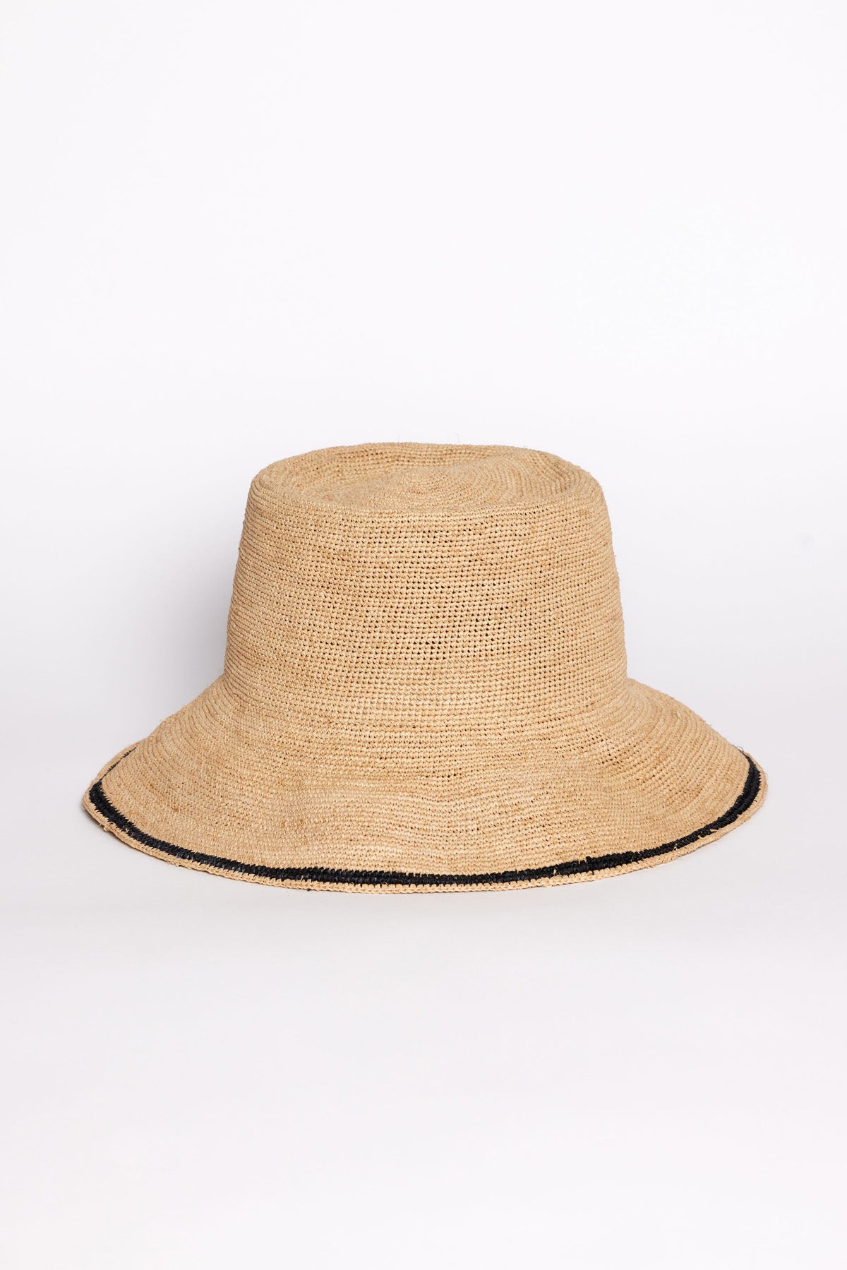 The STRIPE EDGE MODERN CROCHET BUCKET HAT by Velvet by Graham & Spencer is a woven beige bucket hat with a wide brim and a thin black stripe near the edge, shown on a plain white background.