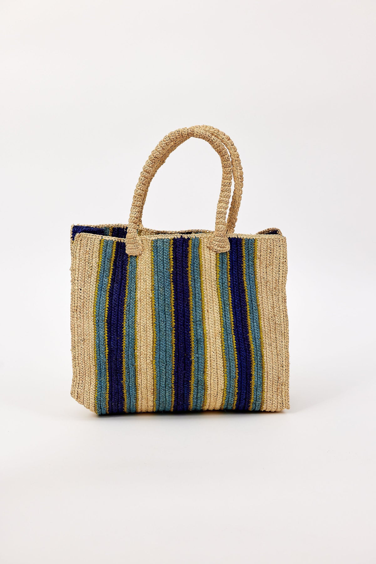 The ARLINGTON TOTE by Velvet by Graham & Spencer is a woven raffia bag with blue, green, yellow, and natural vertical stripes and two handles, shown against a plain white background.