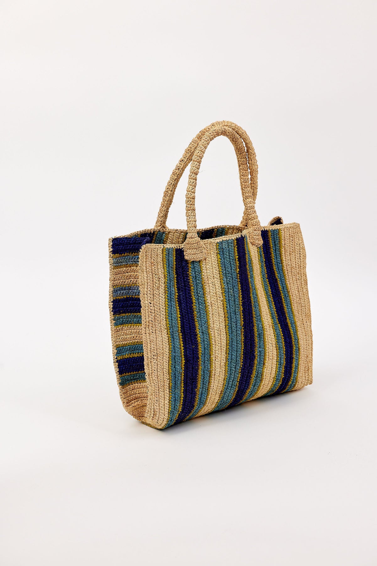 The ARLINGTON TOTE by Velvet by Graham & Spencer is a handcrafted raffia bag with blue, green, and beige stripes and sturdy handles—ideal as a beach tote—shown against a plain white background.-41393580998849