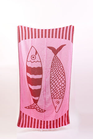 The NOVELTY TURKISH TOWEL by Velvet by Graham & Spencer is a rectangular pink cotton towel featuring two large fish illustrations and vertical stripes along the edges.