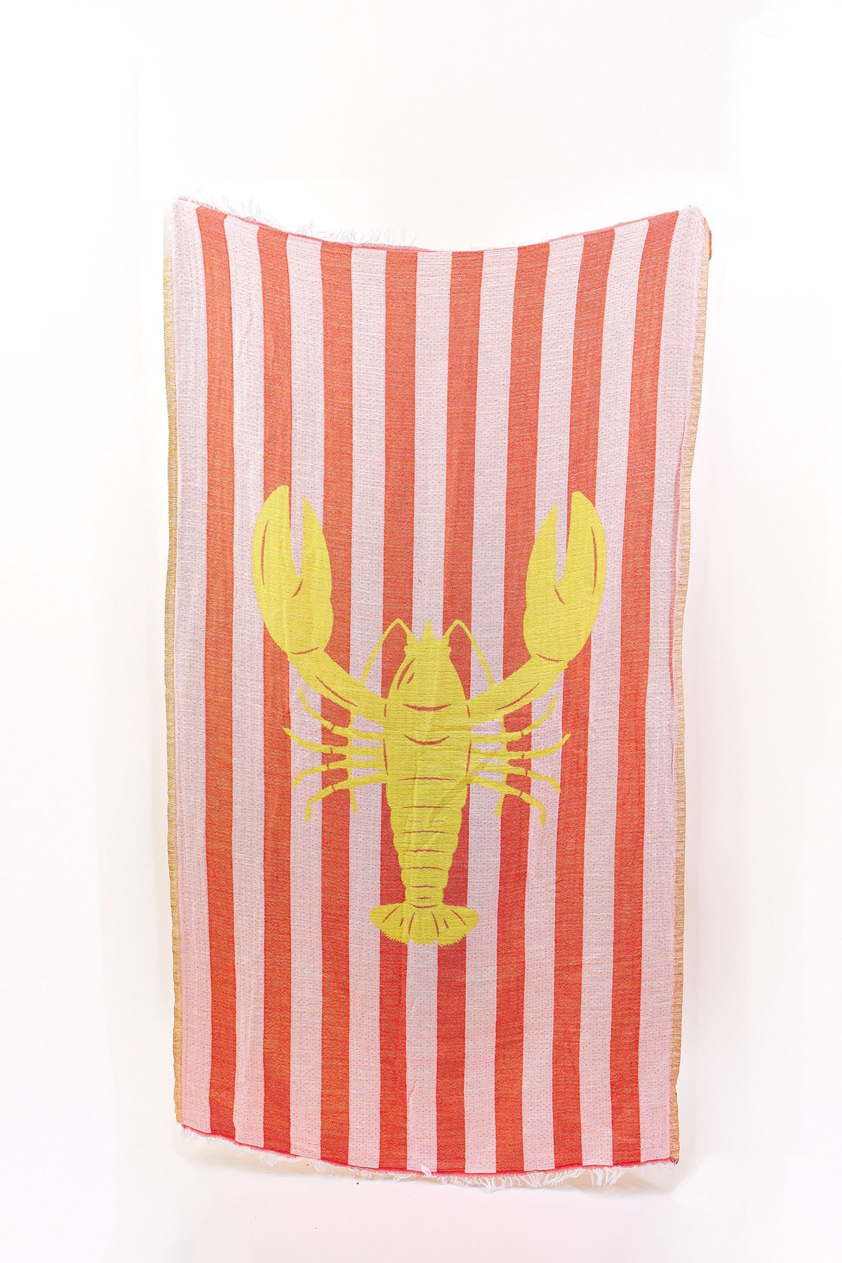 The NOVELTY TURKISH TOWEL by Velvet by Graham & Spencer has vertical red and white stripes with a large yellow lobster in the center, adding a vibrant touch to your beach days.-41332175143105