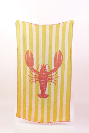The NOVELTY TURKISH TOWEL by Velvet by Graham & Spencer features yellow and white stripes with a bold red lobster design—ideal as a playful beach blanket for sunny days.