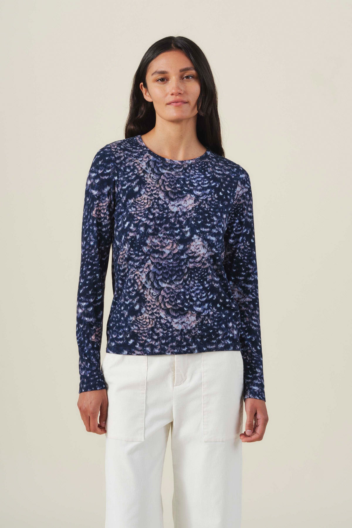 Velvet by Graham & Spencer LILIAN PRINTED TEE, a long-sleeved feather jersey crew neck t-shirt in a dark blue and lavender feather-like print, worn with cream trousers.
