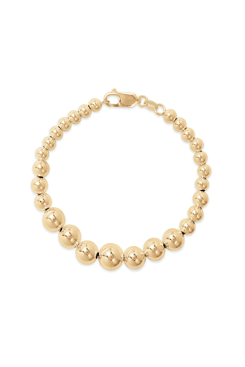 The Graduate Bracelet by Phyllis+Rosie, featuring a gold beaded design and lobster clasp closure, effortlessly chic and reminiscent of vintage street culture.