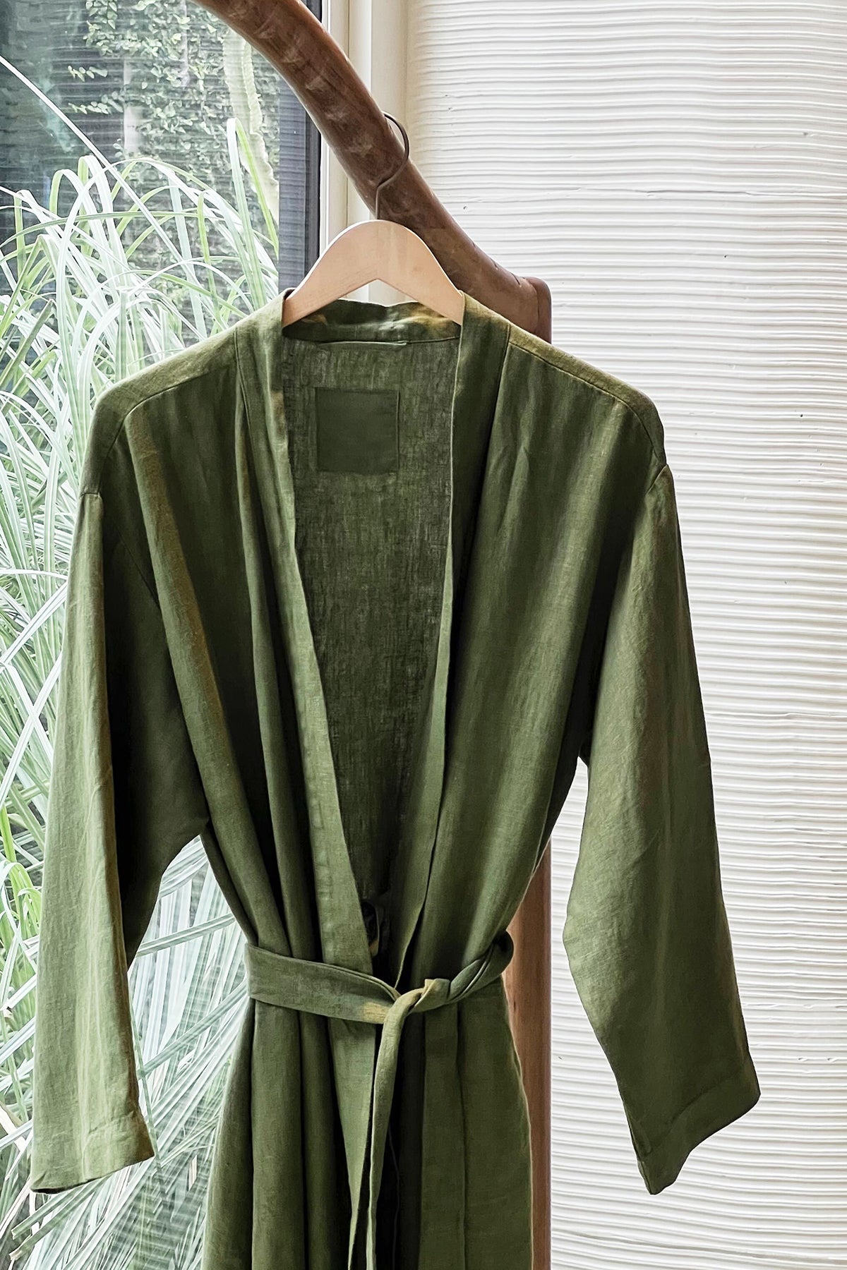 Jenny Graham Linen Robe in basil green on hanger near window-26312946745537