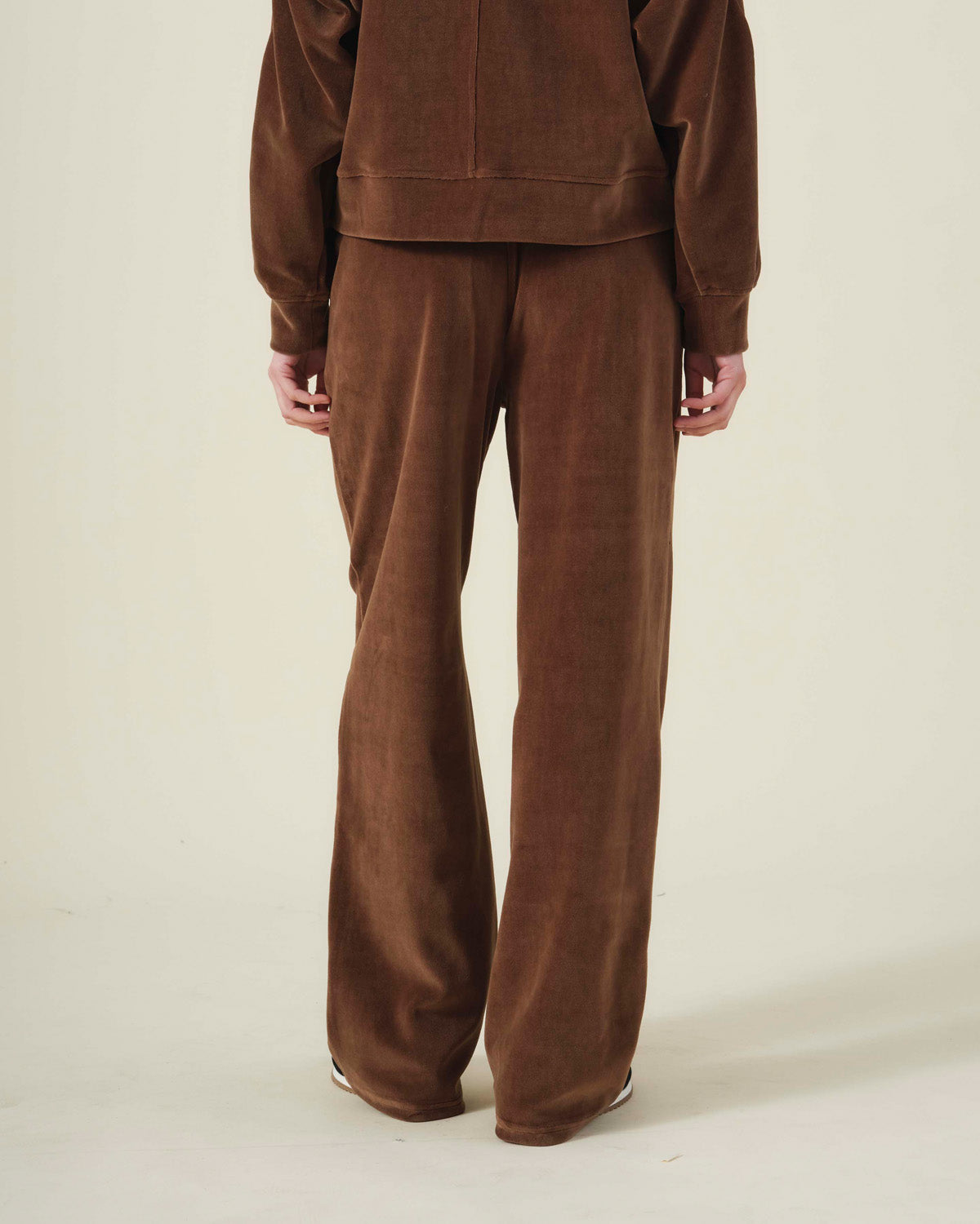 Rear view of a person wearing brown DAISY VELOUR TRACK PANT and a matching plush, long-sleeved top.