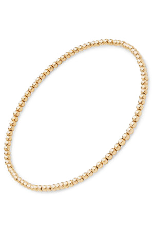 The MINI MOON BRACELET BY PHYLLIS AND ROSIE from Phyllis+Rosie is a hand-crafted gold beaded bracelet, composed of small round beads strung together in a continuous loop, reflecting the essence of New York City's vintage street culture.