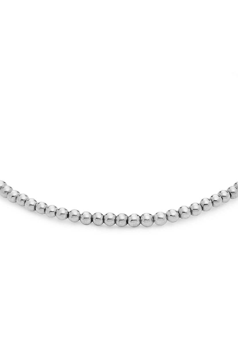 A close-up view of the MINI MOON BRACELET BY PHYLLIS+ROSIE, a hand crafted beaded bracelet with spherical silver beads inspired by vintage street culture in New York City.
