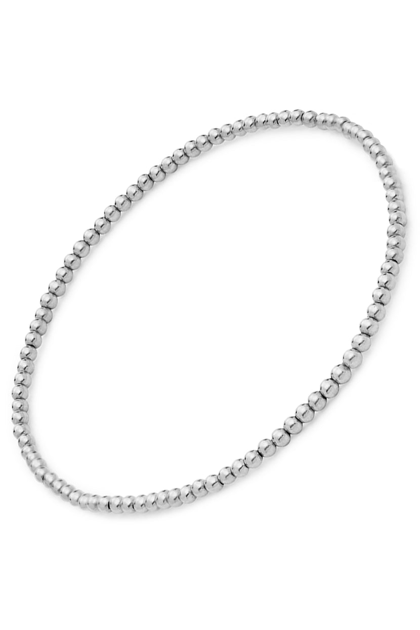 The MINI MOON BRACELET BY PHYLLIS AND ROSIE from Phyllis+Rosie is a silver beaded bracelet with evenly spaced round beads forming a continuous loop, inspired by the vintage street culture of New York City. This hand-crafted jewelry embodies urban elegance.