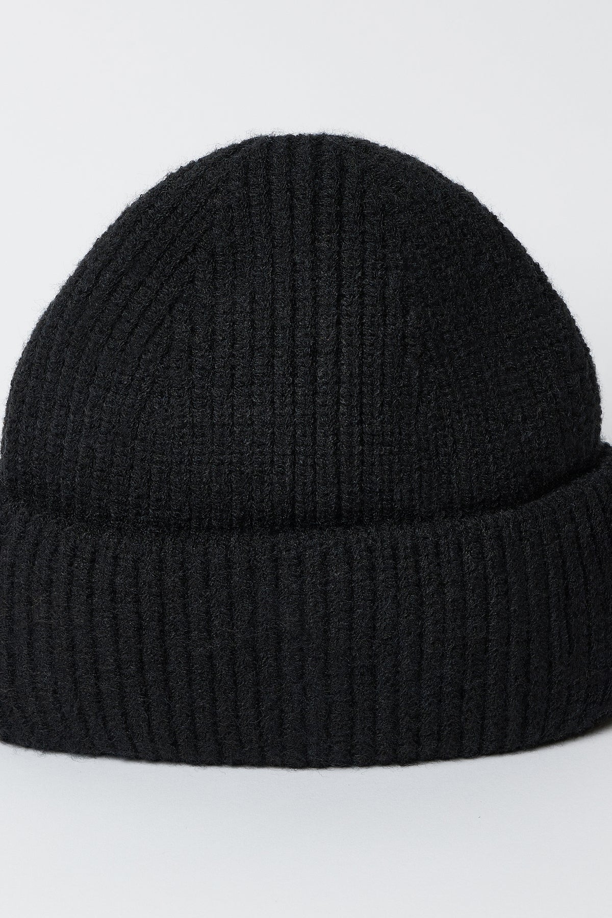   The MAJOR BEANIE by Velvet by Graham & Spencer, a black ribbed-knit hat with a classic cuffed design, is showcased against a simple white background. Ideal for winter weather, this unisex beanie blends style and warmth seamlessly. 