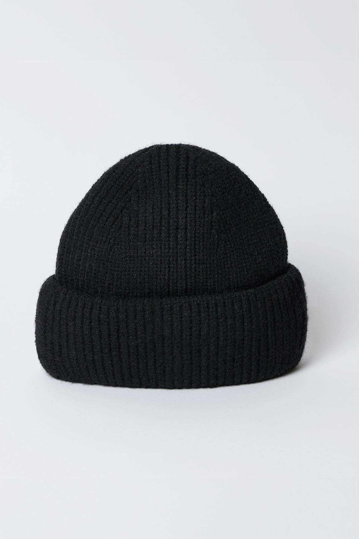   The MAJOR BEANIE by Velvet by Graham & Spencer is a black knit beanie hat featuring a classic cuffed design set against a white background, ideal for winter weather and perfect as a unisex accessory. 