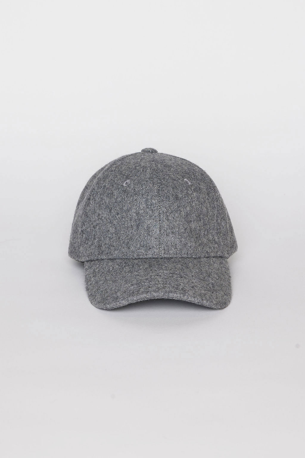   The SOLID SHETLAND CAP by Velvet by Graham & Spencer is a gray baseball cap featuring a curved brim and two ventilation holes on the front panels, displayed against a plain white background. 