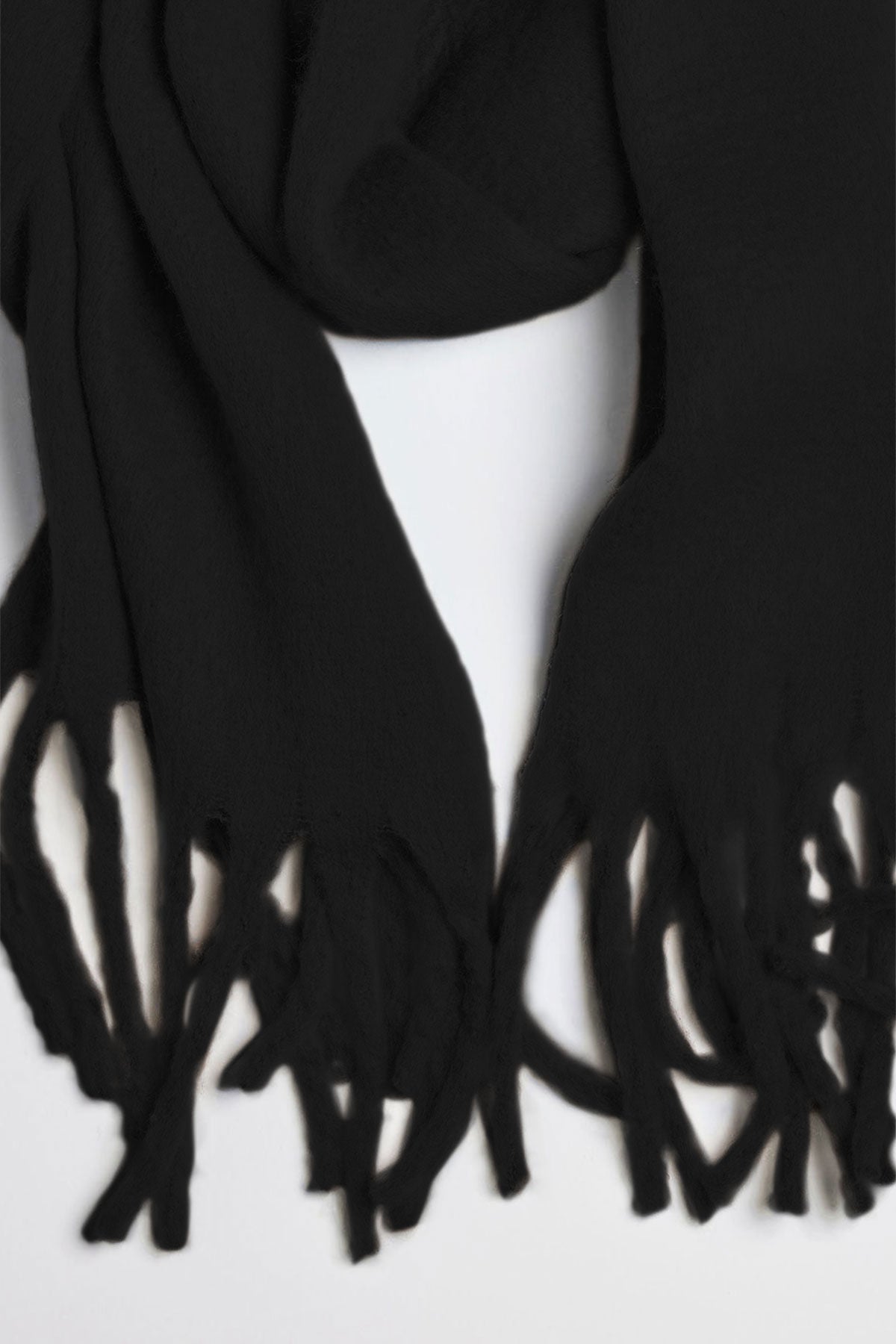   The CHIC SOLID SCARF by Velvet by Graham & Spencer, featuring fringes at both ends, is displayed against a light background. 