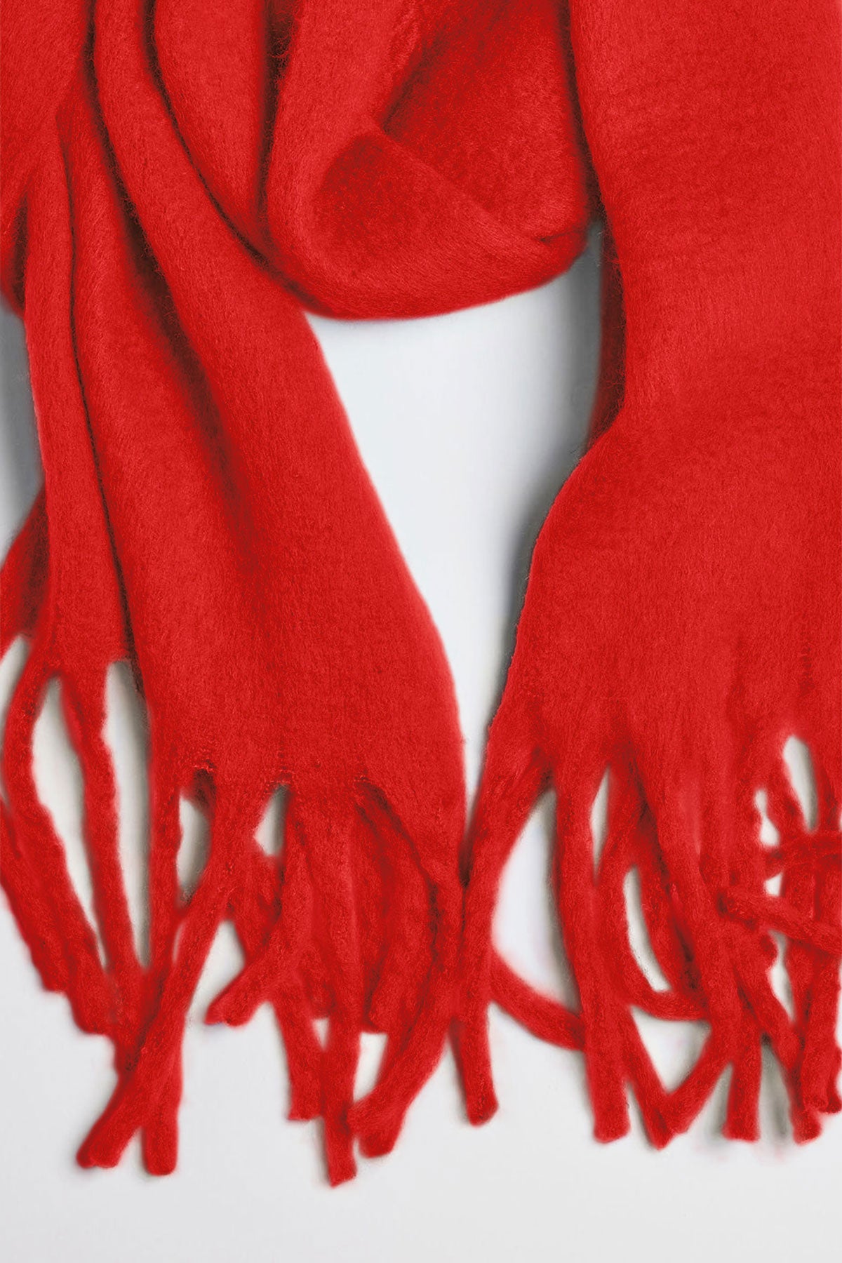   A close-up of the CHIC SOLID SCARF by Velvet by Graham & Spencer, featuring fringe detailing, on a white background. 