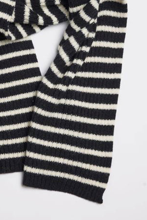 A close-up view of the BOLTON STRIPE SCARF by Velvet by Graham & Spencer, featuring black and white striped, ribbed fabric, displayed laid flat.